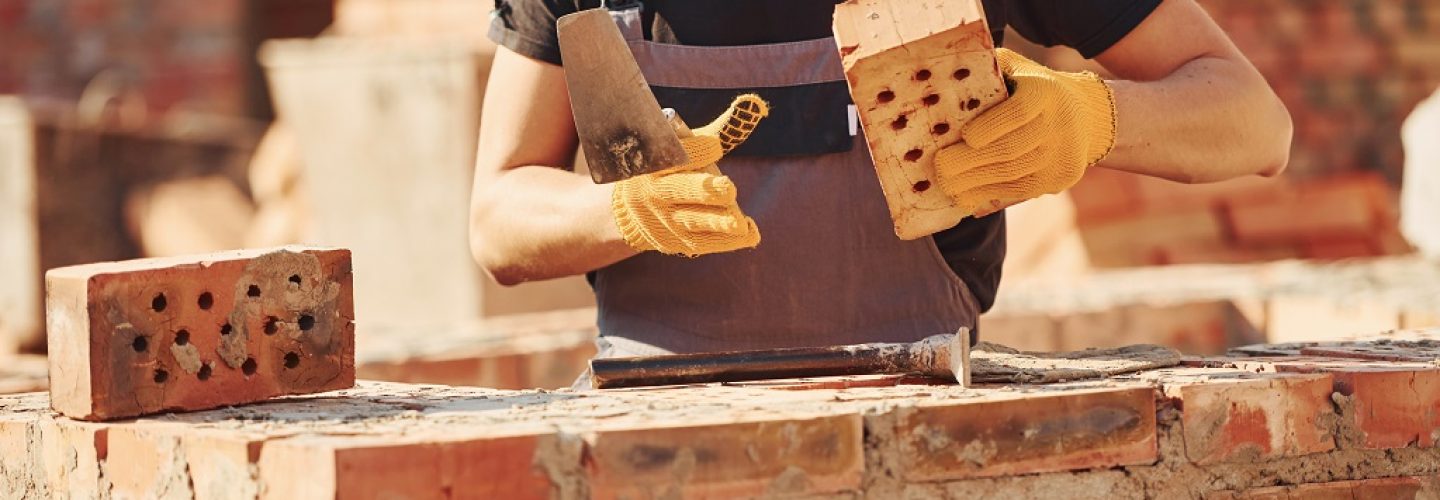 Construction worker in uniform and safety equipment have job on building.